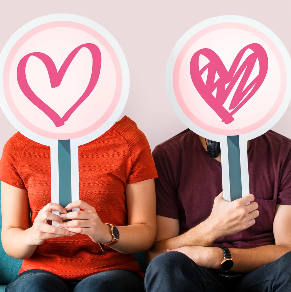 Two people holding heart symbols representing sexual health screening