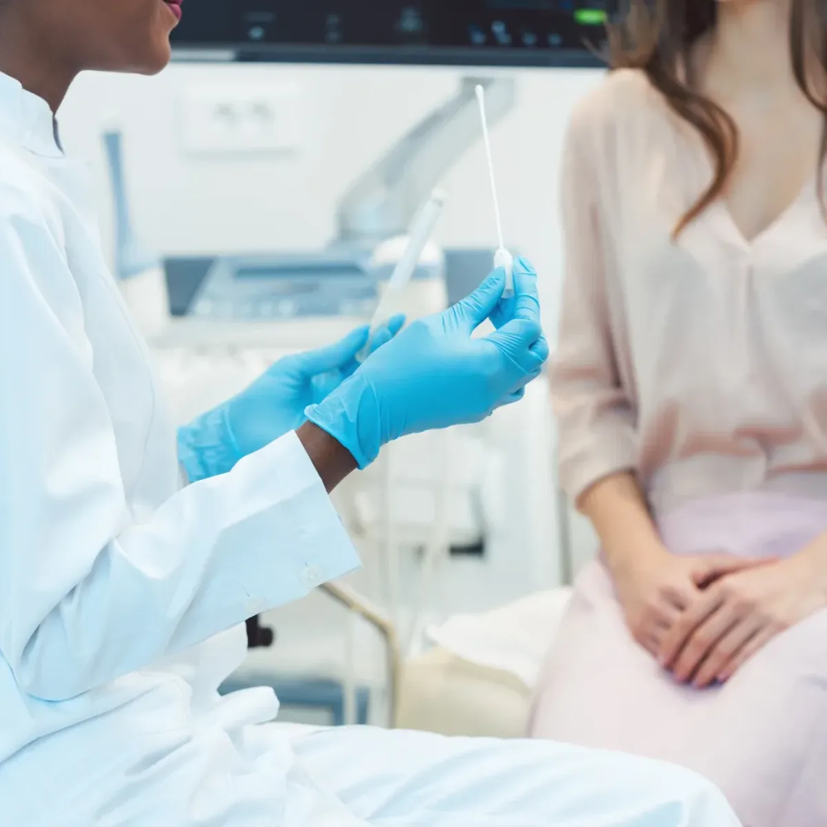 DHA-licensed clinician preparing a sterile swab beside a seated female patient for a discreet candida and yeast infection test at home in Dubai