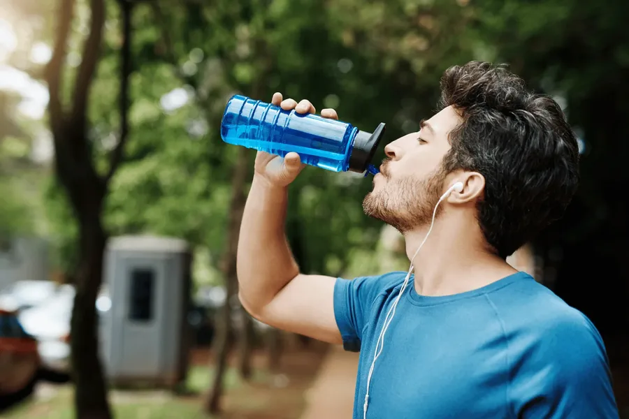 Man drinking water after outdoor exercise