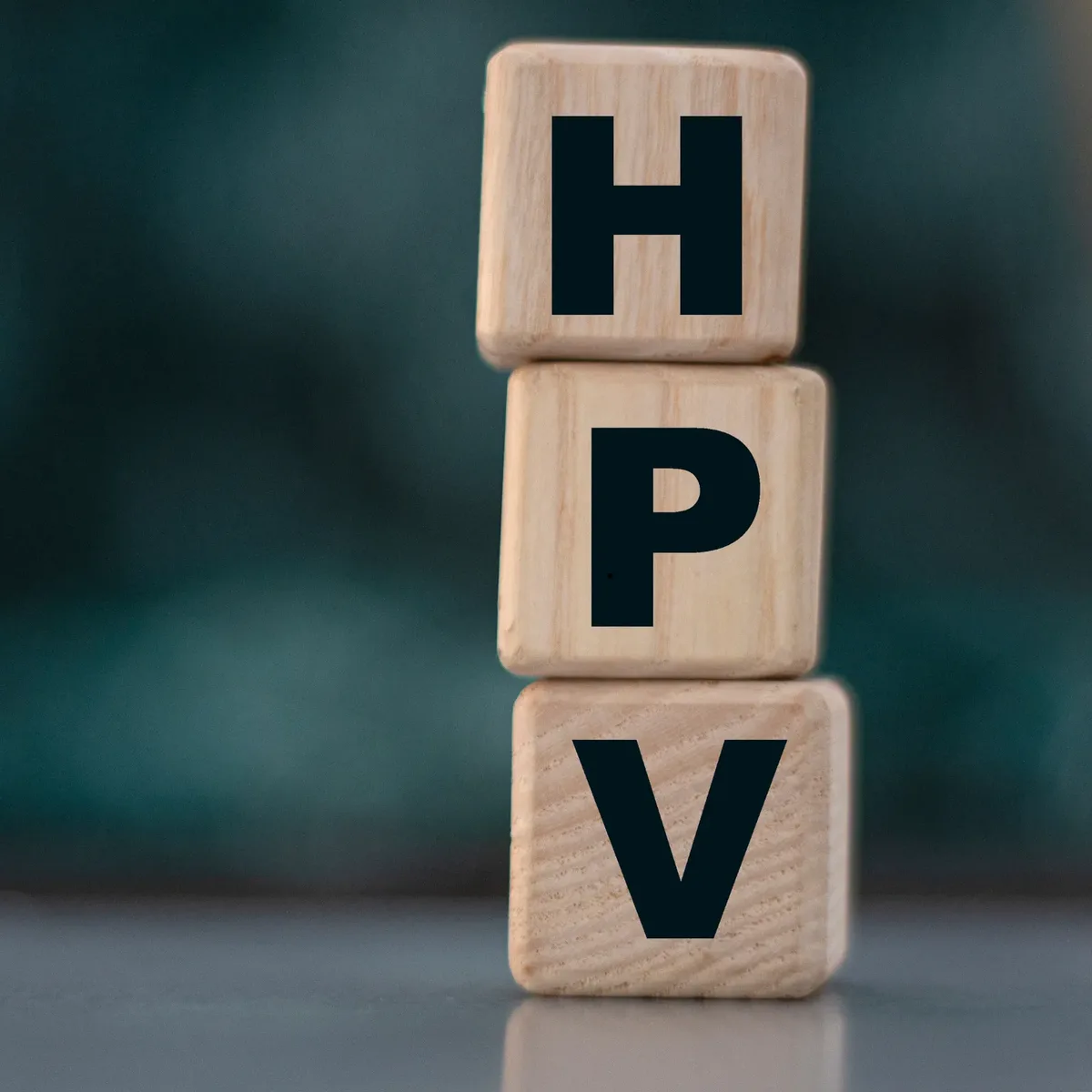 Wooden blocks spelling HPV stacked on a desk, representing confidential Human Papillomavirus testing at home in Dubai with Vesta Care