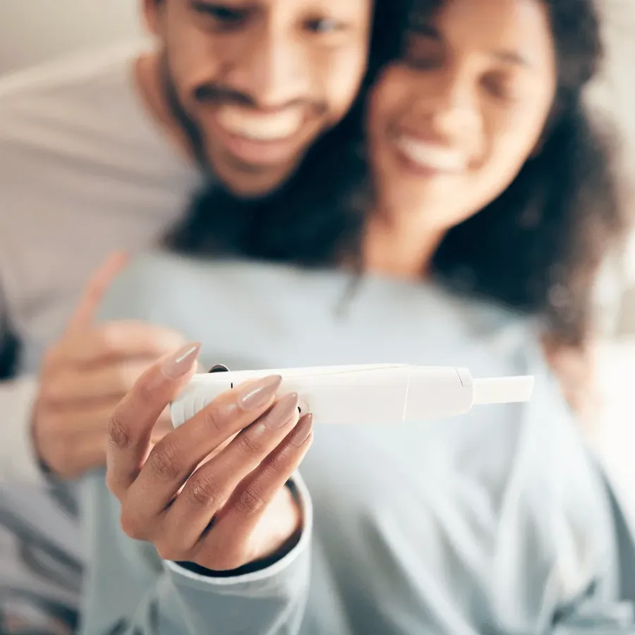 A couple sitting together at home in Dubai reading the result of a home pregnancy test before arranging a fertility blood test