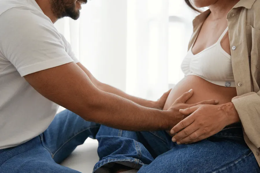 Expectant couple resting their hands on a pregnancy bump