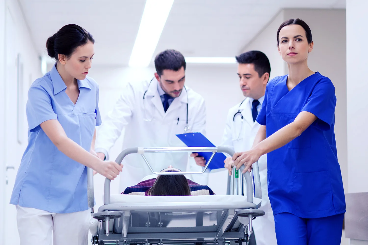 Hospital clinicians responding to a patient on a stretcher