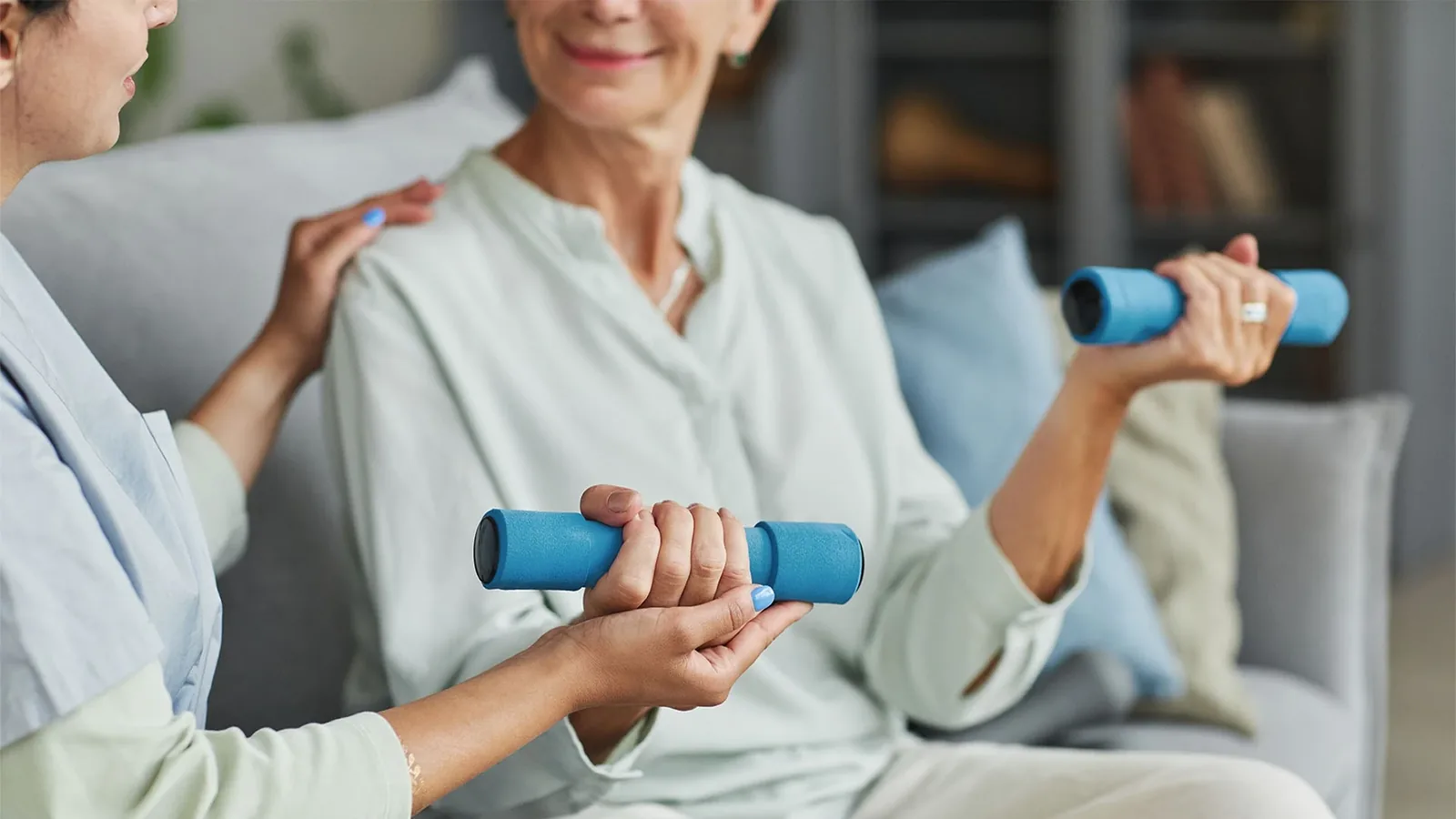 Older woman exercising with dumbbells under clinical guidance