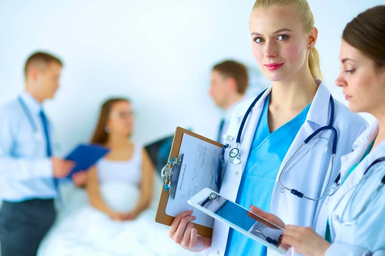 Hospital clinician with a patient receiving care in the background