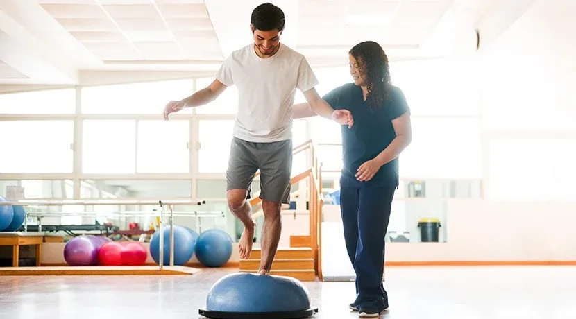 Physiotherapist helping a patient practise standing balance