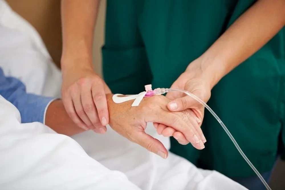 Nurse inserting an intravenous cannula into a patient's hand