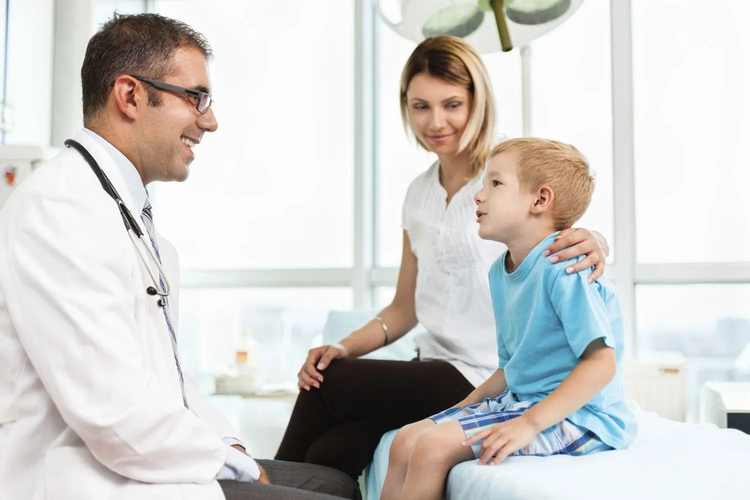 Paediatrician examining a child with their mother during a home visit in Dubai