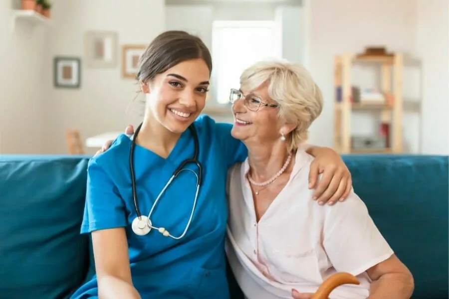 Nurse smiling with an older woman at home