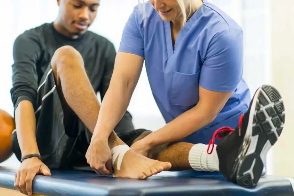 Physiotherapist treating a sports injury at a visitor’s location in Dubai
