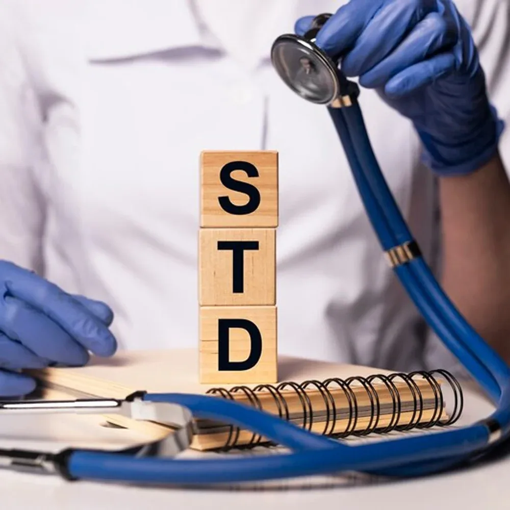 STD letter blocks beside a stethoscope and medical notes