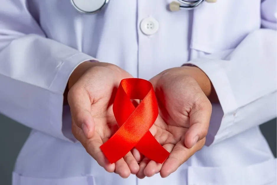 Clinician holding a red HIV awareness ribbon