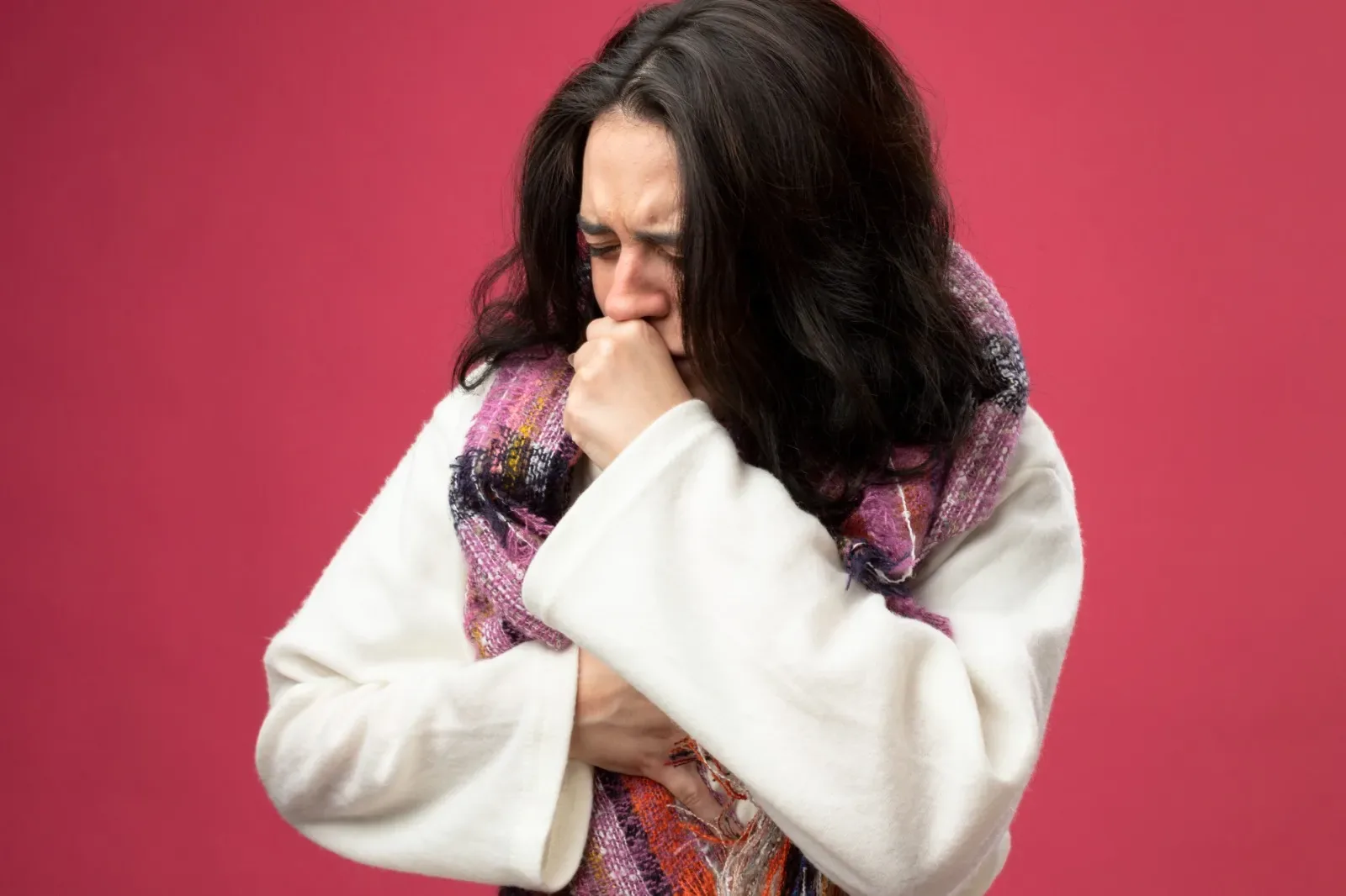 Ill woman coughing into her sleeve