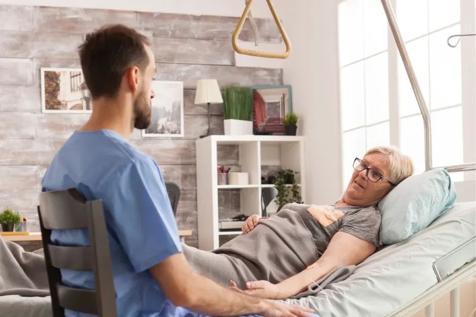 Nurse caring for an older man resting in bed