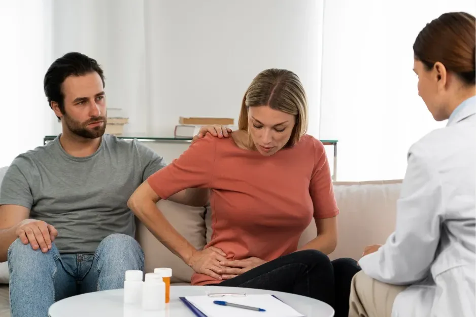 Doctor consulting a couple about abdominal discomfort