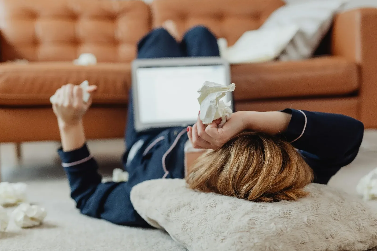 Woman resting on a sofa with cold and flu symptoms